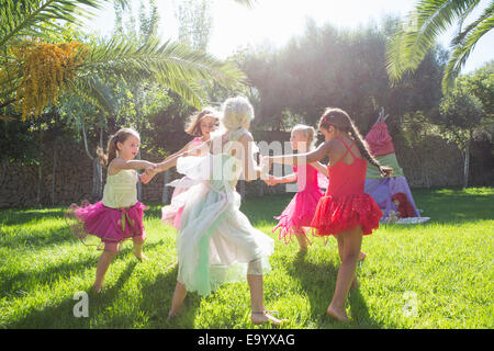 Cinq filles énergiques dans fairy costume playing in garden Banque D'Images