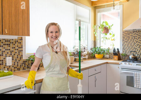 Jeune femme cuisine nettoyage avec produits de nettoyage écologiques Banque D'Images