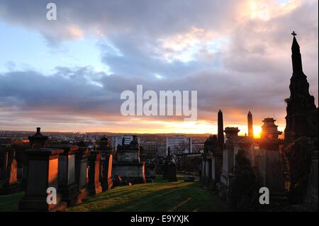 Glasgow, Ecosse, Royaume-Uni. 4ème Nov, 2014. Météo : Le soleil se couche sur les pierres tombales de la Nécropole à Glasgow Crédit : Tony Clerkson/Alamy Live News Banque D'Images