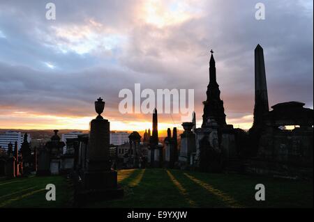 Glasgow, Ecosse, Royaume-Uni. 4ème Nov, 2014. Météo : Le soleil se couche sur les pierres tombales de la Nécropole à Glasgow Crédit : Tony Clerkson/Alamy Live News Banque D'Images