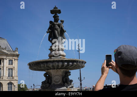 Man taking photograph, Place de la Bourse (Place Royale), Bordeaux, France Banque D'Images