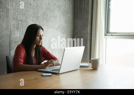 Woman using laptop at home Banque D'Images
