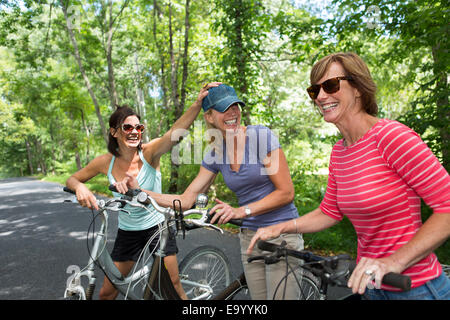 Femme mature avec trois bicyclettes le long de routes de campagne Banque D'Images