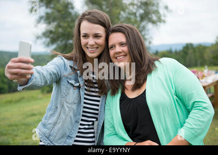 Deux amies taking self portrait à l'aide de l'extérieur, smartphone Banque D'Images Deux amies taking self portrait à l'aide de l'extérieur, smartphone Banque D'Images