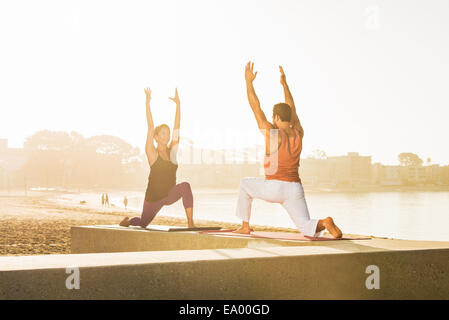 Young man and woman practicing yoga on pier à Pacific Beach, San Diego, California, USA Banque D'Images