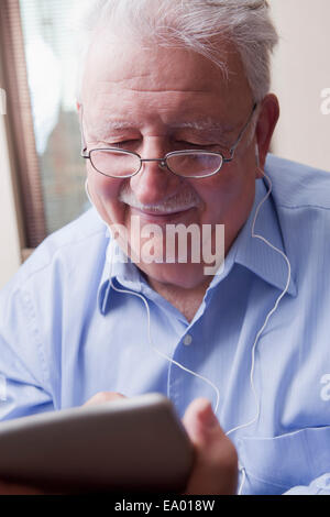 Senior man reading digital tablet Banque D'Images