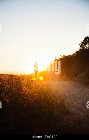 Female jogger s'exécutant dans la lumière du soleil, Poway, CA, USA Banque D'Images