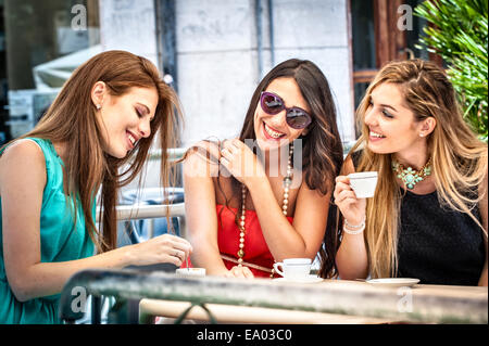 Trois jeunes amis féminins espresso potable at sidewalk cafe, Cagliari, Sardaigne, Italie Banque D'Images