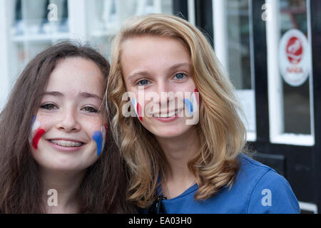 Jeunes étudiantes visiter Suffolk célébrer le jour de la Bastille par peindre le drapeau français sur leurs visages. Banque D'Images