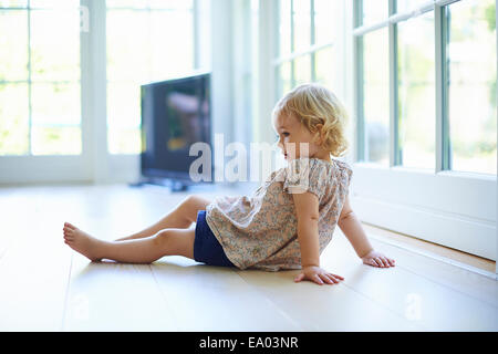 Portrait young woman sitting on plancher du salon Banque D'Images