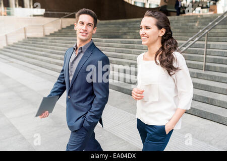 Young businessman and woman chatting en marchant, London, UK Banque D'Images