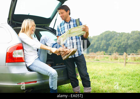 Couple à l'arrière de la voiture pour préparer la lecture de carte de marche Banque D'Images