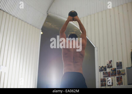 Man lifting kettlebell in gym Banque D'Images