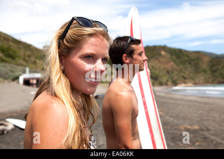 Jeune couple standing on beach looking out to sea Banque D'Images