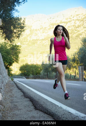 Teenage girl running on road, Majorque, Espagne Banque D'Images