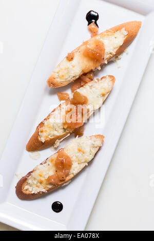 Toast bruschettes garnir de fromage et de confiture de coings sur fond blanc Banque D'Images