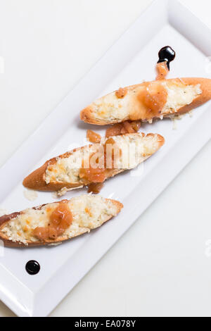 Toast bruschettes garnir de fromage et de confiture de coings sur fond blanc Banque D'Images