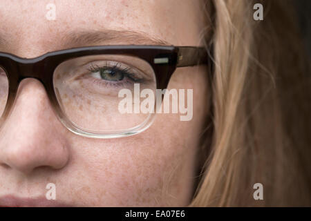 Close-up of young woman with freckles portant des lunettes Banque D'Images