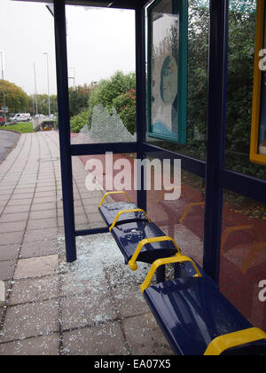 Un abri d'autobus urbain avec une vitre cassée et le verre se trouvant autour de l'étage Banque D'Images