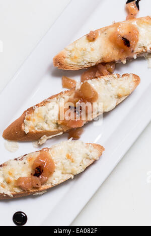 Toast bruschettes garnir de fromage et de confiture de coings sur fond blanc Banque D'Images