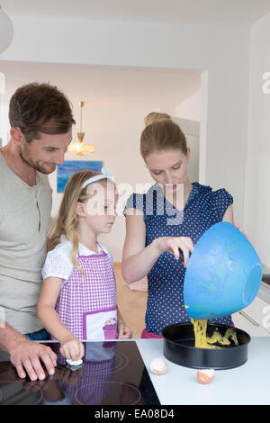 Woman pouring mélange dans un moule à gâteau Banque D'Images