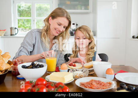 Mère et fille manger à la table de cuisine Banque D'Images