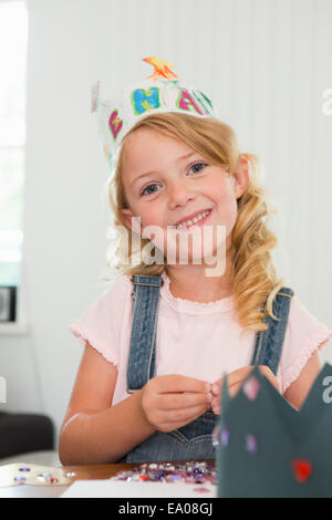 Girl making paper crown Banque D'Images