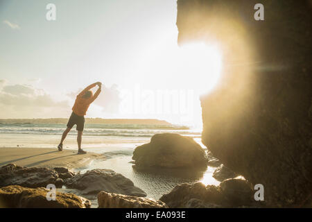 Man exercising on beach, face à la mer Banque D'Images