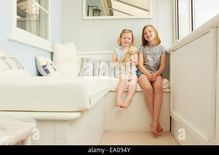 Portrait de deux soeurs assis dans maison de vacances porche Banque D'Images