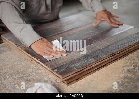 Lissage de surface charpentier la planche en bois avec du papier de verre en usine, Jiangsu, Chine Banque D'Images