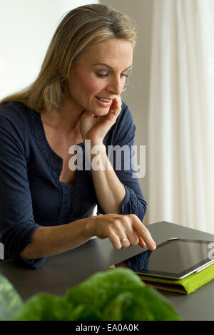 Mature Woman using digital tablet Banque D'Images
