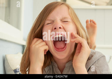 Fille aux yeux fermés hurlements dans maison de vacances Banque D'Images