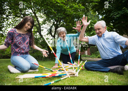 Les grands-parents et sa petite-fille jouant pick up sticks géant Banque D'Images
