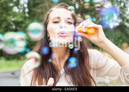 Young woman blowing bubbles Banque D'Images
