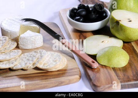 Le camembert avec les poires et les olives sur les planches de bois sur le tableau blanc de près. Banque D'Images