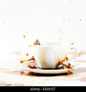 Tasse de café renverser de créer de belles splash avec taches sur le blanc. Pause-café, le petit-déjeuner gratuit. Banque D'Images