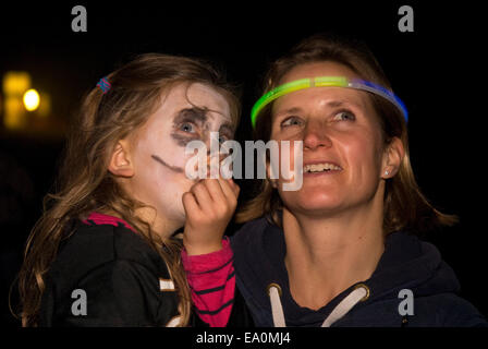 Mère avec une jeune fille regardant un feu d'artifice sur Halloween, Buriton, Hampshire, Royaume-Uni. Banque D'Images