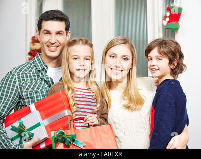 Famille heureuse avec deux enfants avec des cadeaux à la veille de Noël Banque D'Images