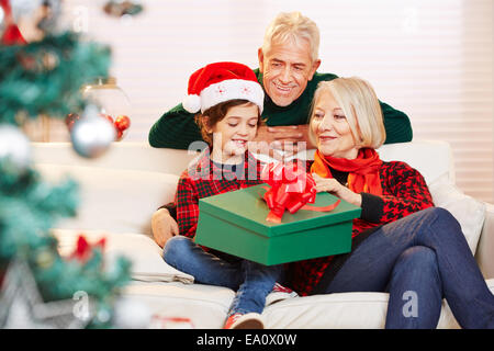 Ouverture garçon cadeau à Noël avec ses grands-parents Banque D'Images