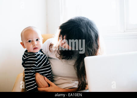 Mère à l'aide d'un ordinateur portable avec son on lap Banque D'Images