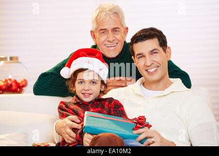 Heureux l'enfant célébrer Noël avec un père et un grand-père et cadeaux Banque D'Images