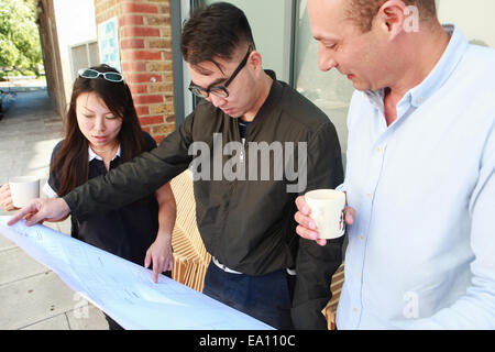 Trois collègues architecte bureau extérieur plan directeur de l'inspection Banque D'Images