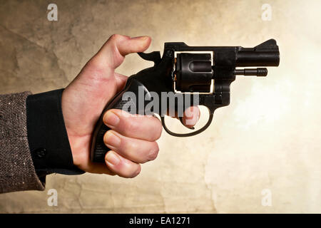 Silhouette d'un homme part avec un revolver en brun Banque D'Images