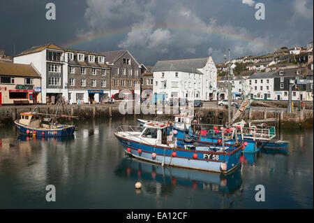 Les nuages de tempête et un arc-en-ciel sur les bateaux de pêche à Mevagissey harbour, Cornwall. Banque D'Images