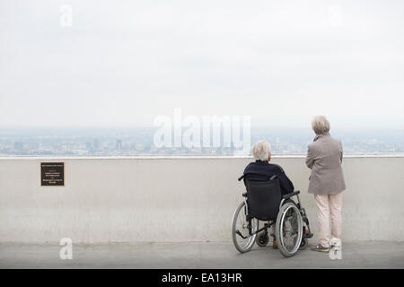 Vue arrière du man en fauteuil roulant et son épouse à la ville à partir de l'affichage à l'Observatoire de Griffith Park balcon Los Angeles Banque D'Images