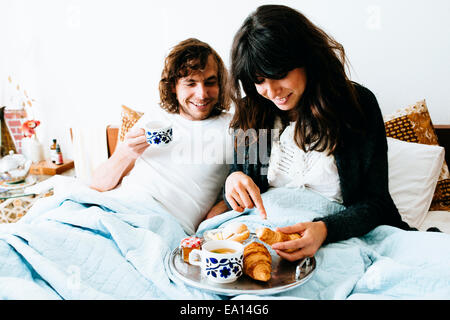 Couple having breakfast in bed Banque D'Images