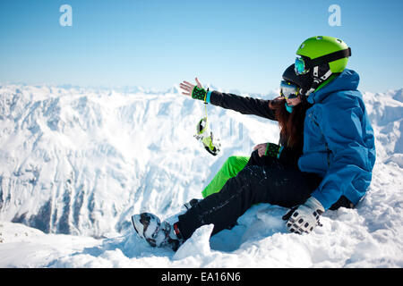 Jeune couple heureux dans les montagnes enneigées. Banque D'Images