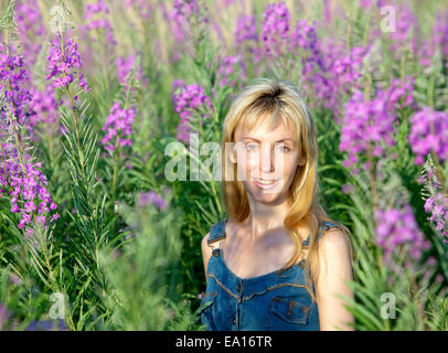 Happy young woman in flowers blooming sally Banque D'Images