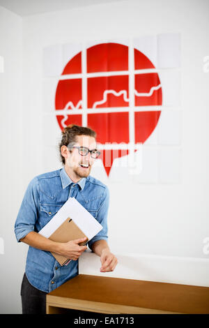 Jeune homme dans le bureau d'études, smiling Banque D'Images