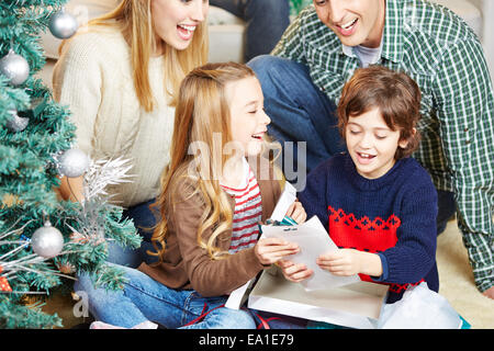 Heureux les enfants se présente de leurs parents à la veille de Noël Banque D'Images